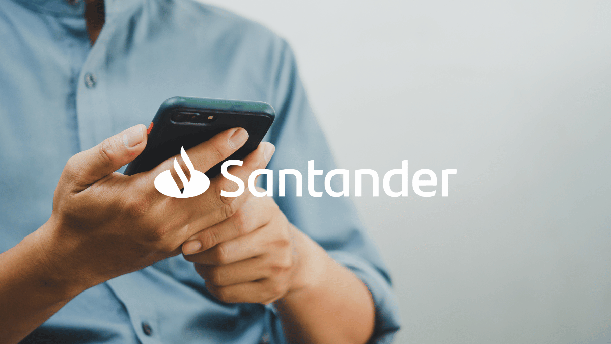 Imagem de um homem (sem mostrar o rosto, apenas braços, mãos e tronco) usando o celular. Logo Santander.
