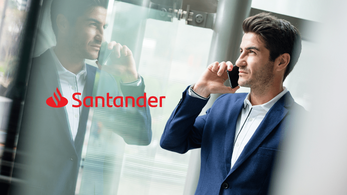 Imagem de um homem branco de mais ou menos 50 anos, usando terno e está falando ao telefone. Ao lado dele está o logo do Santander.